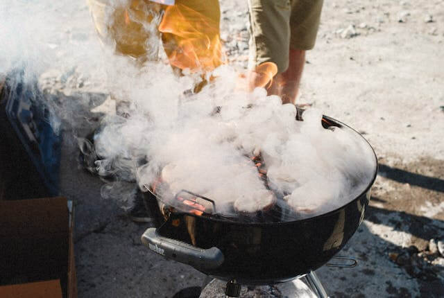A smoker producing thin blue smoke, illustrating the smoking process.